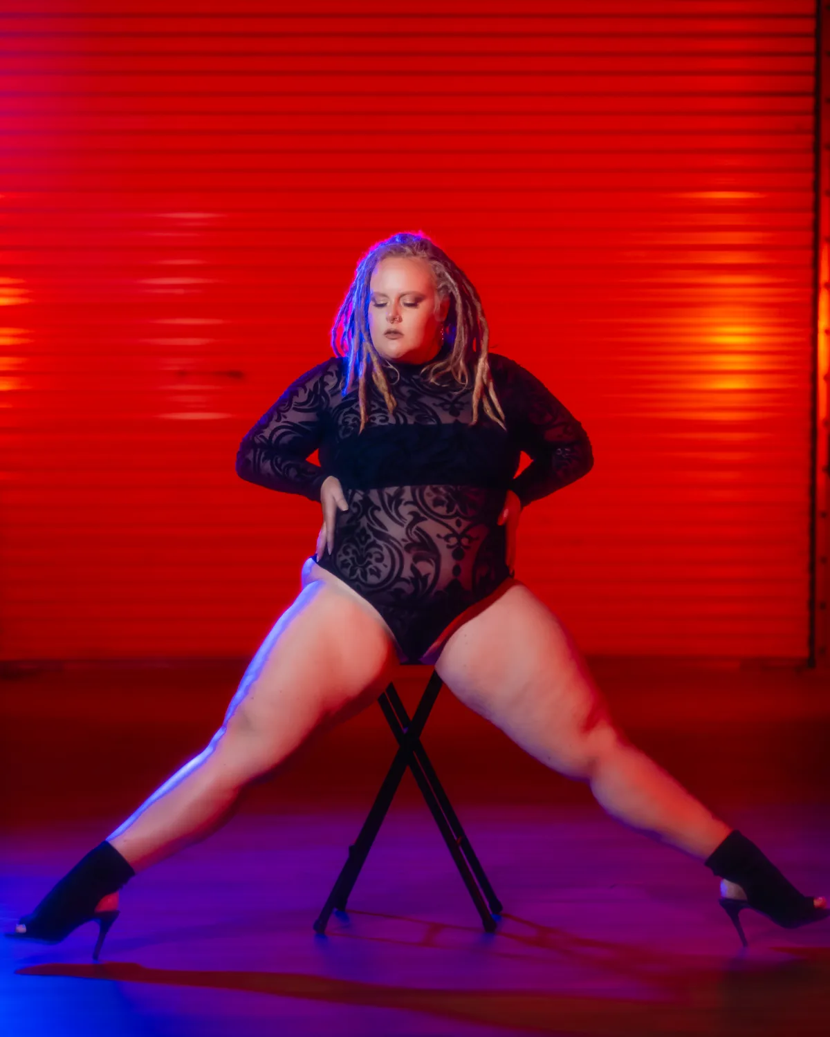 Ava Flynn, co-founder and COO of Atelier Digital, in a dance pose under stage lighting.