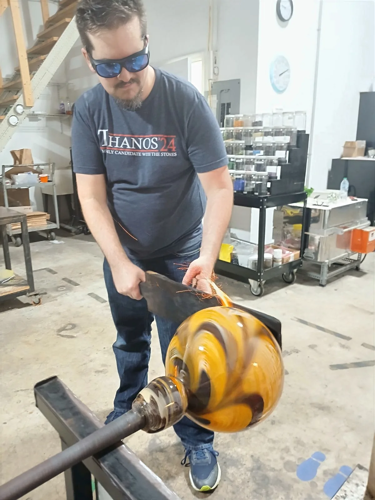 Craig Mackles in his glass studio, working a piece on the punty.